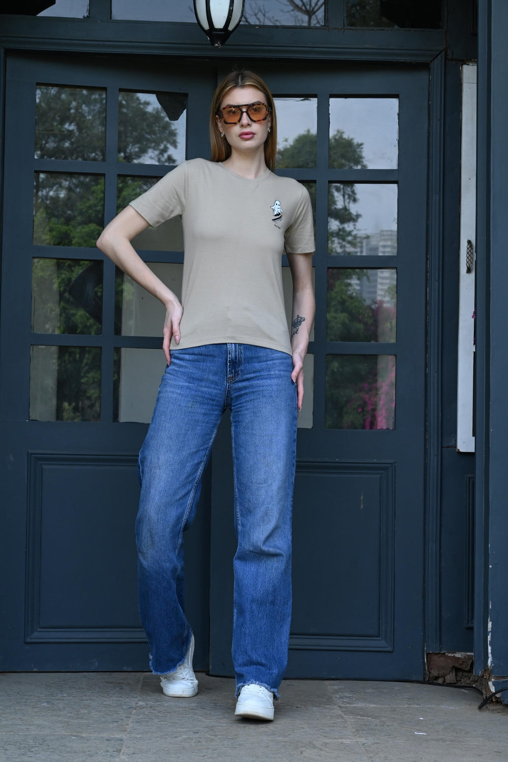 Woman wearing beige t-shirt with ghost sticker print – stylish and fun casual wear