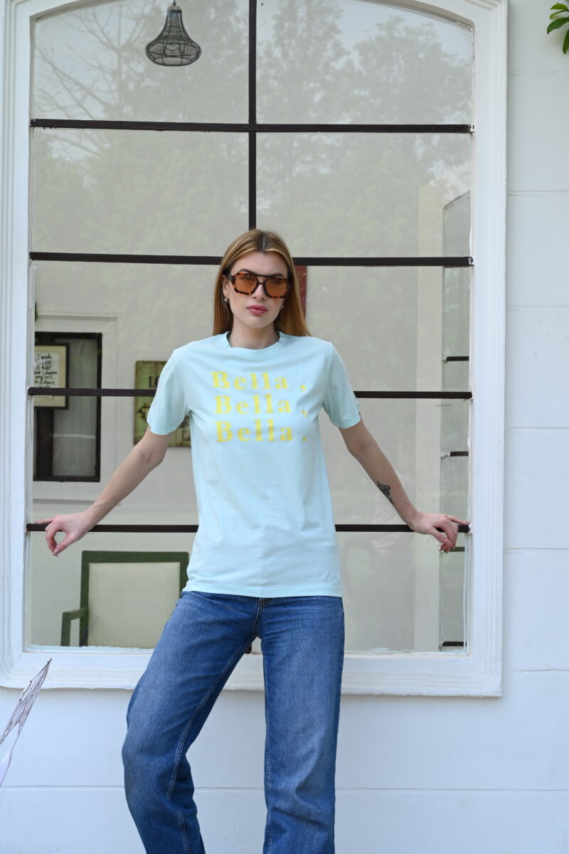Woman wearing light blue cotton t-shirt with yellow “Bella, Bella, Bella.” slogan – casual fashion style